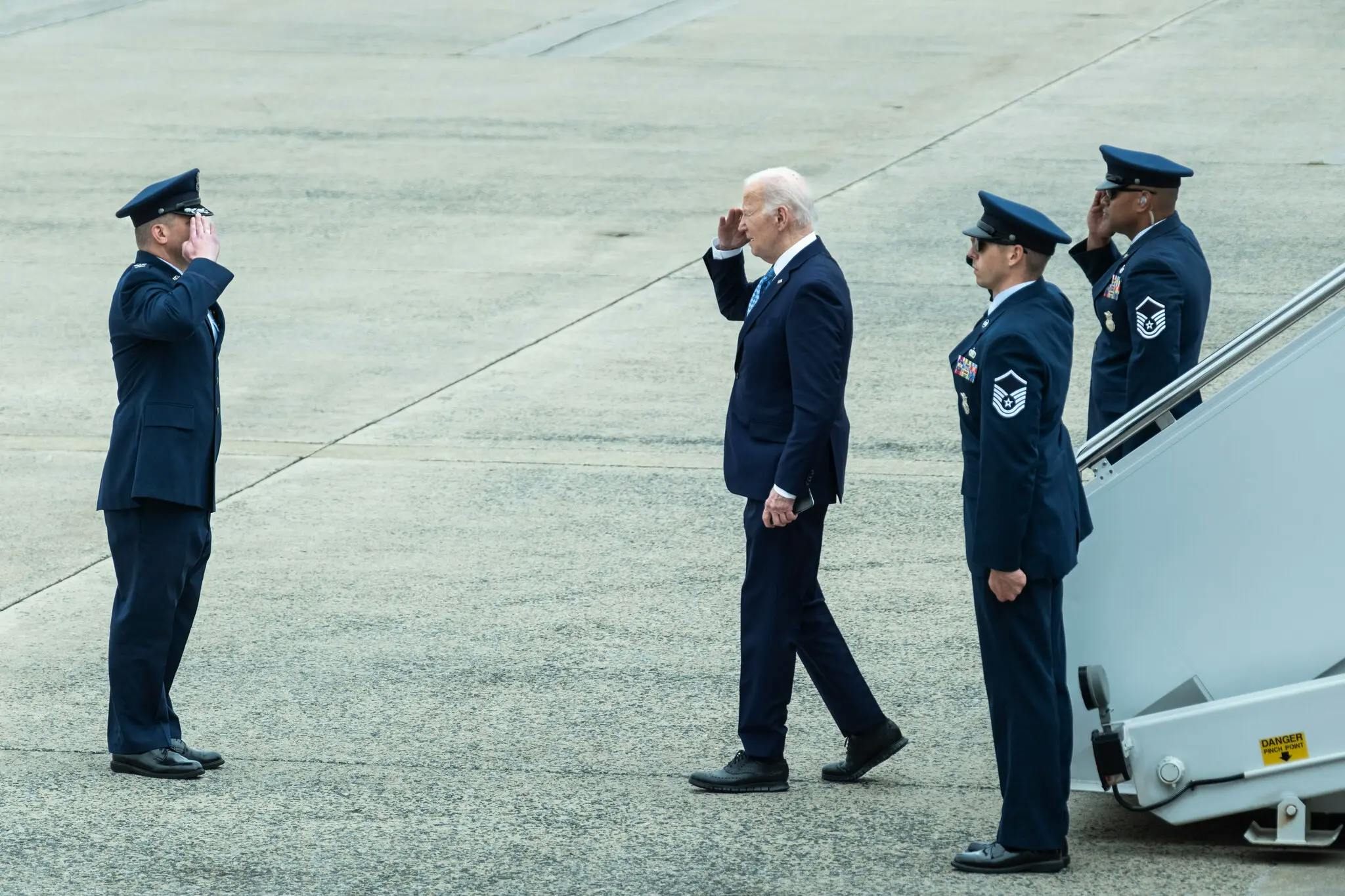 Biden saluting after exiting the plane