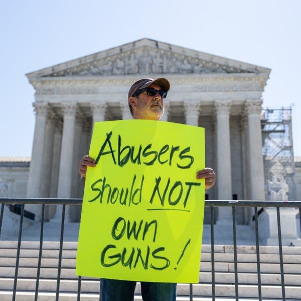 A demonstrator holding a sign outside of the Supreme Court